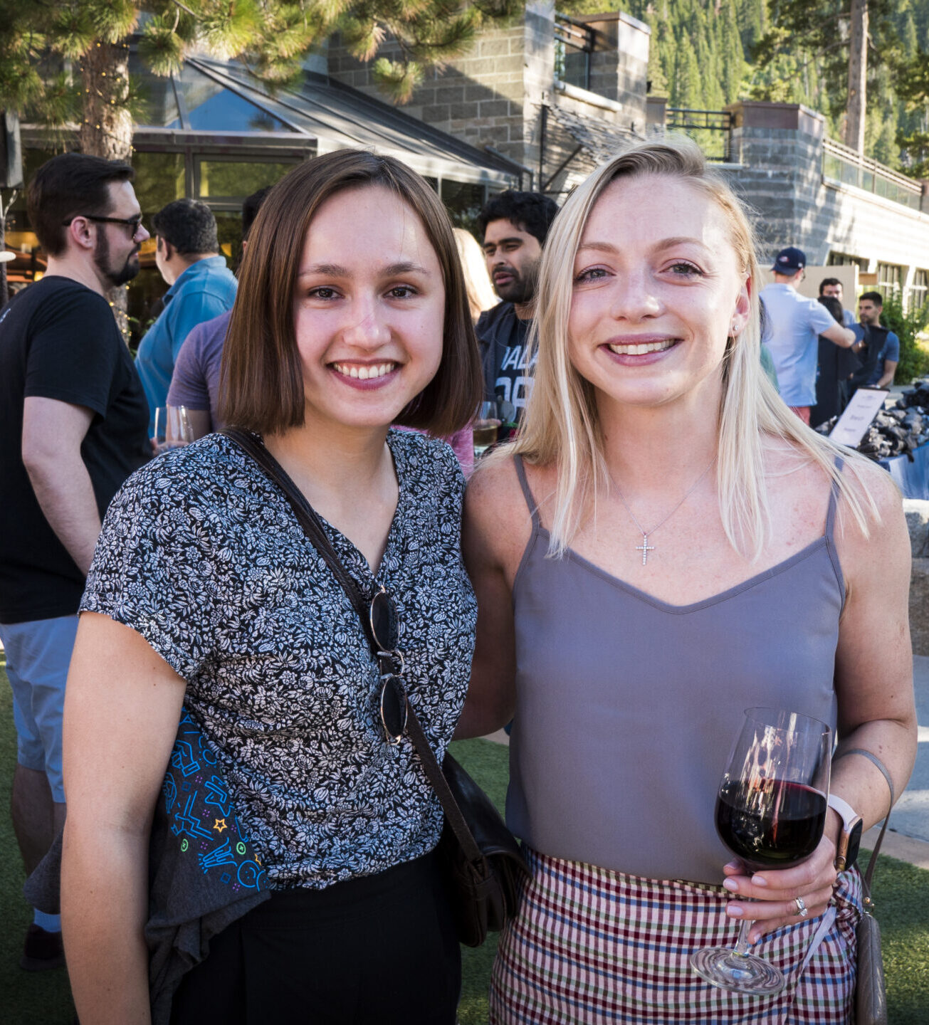 two ladies smiling at camera with wine