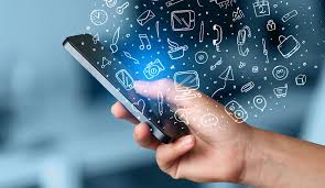 A hand holding a smartphone with various technology and social media icons emanating from the screen.