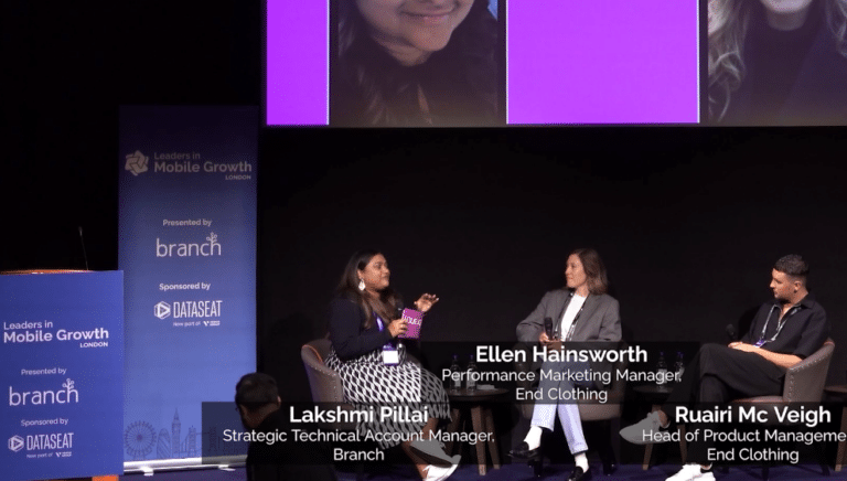 Three panelists seated onstage at a 'Leaders in Mobile Growth' event.